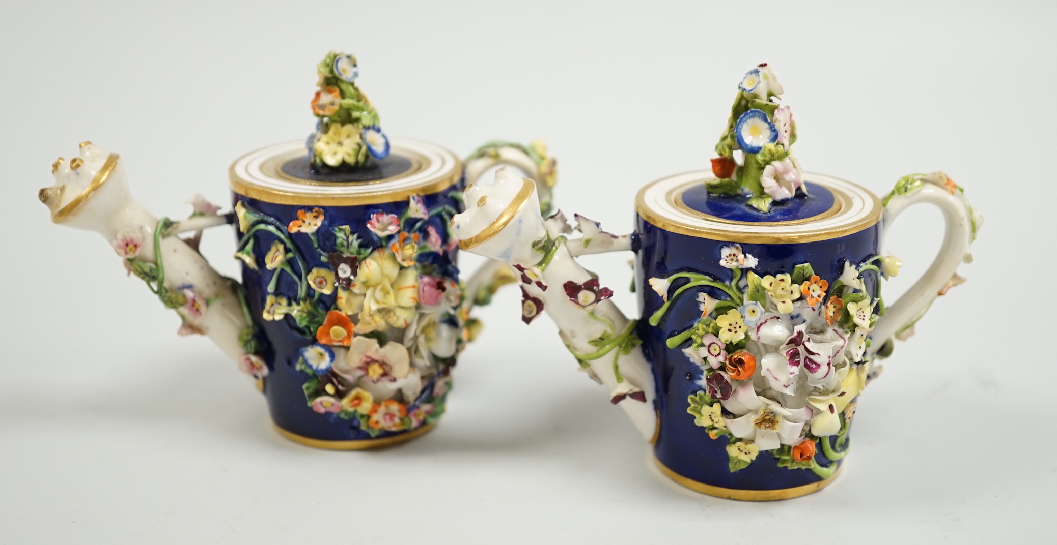 Toy porcelain. Two Bloor Derby flower encrusted rosewater sprinklers, each modelled as a watering can, c.1825, red printed marks, 9cm high